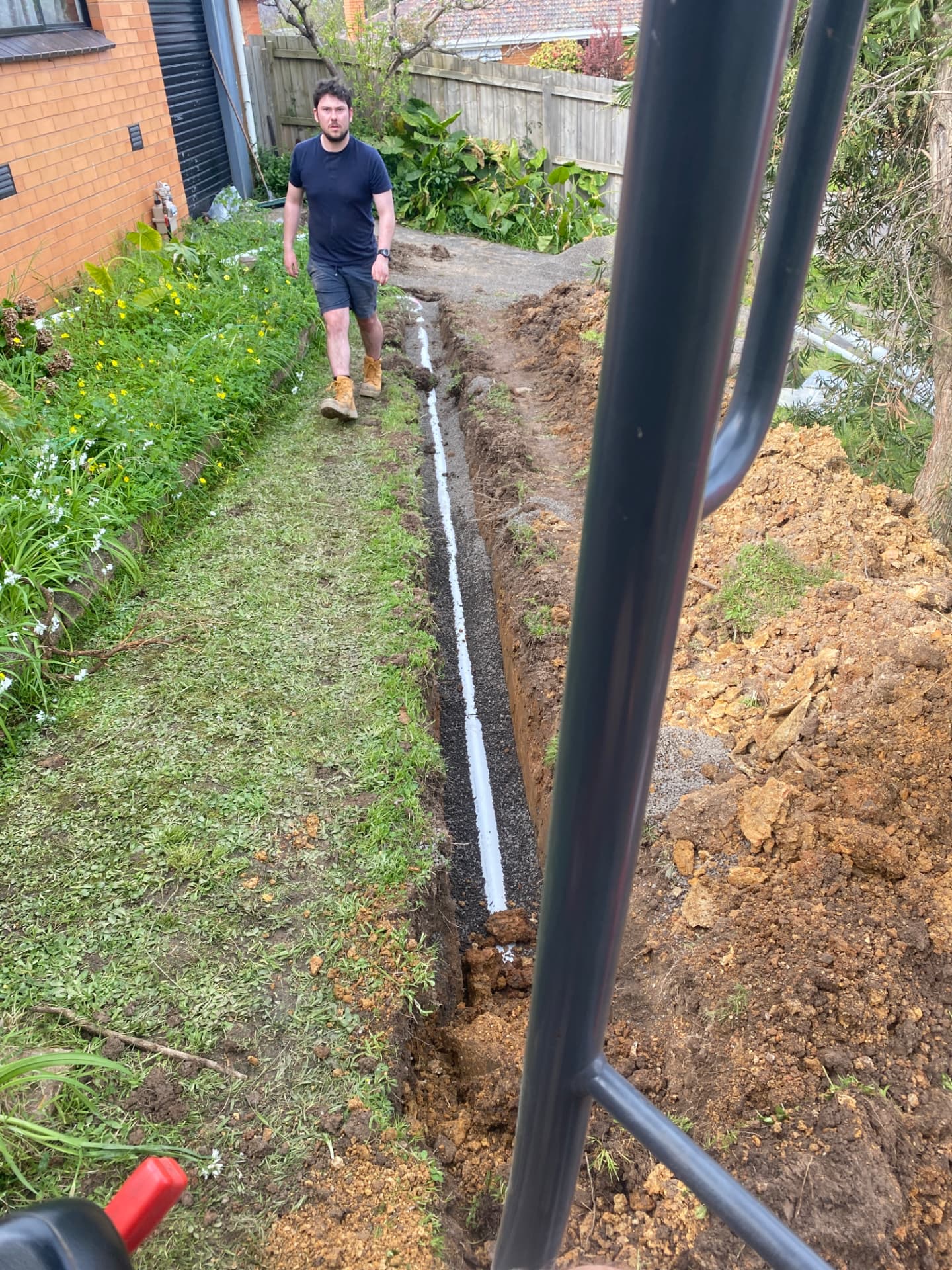 New stormwater line laid in an excavated trench beside a Melbourne home